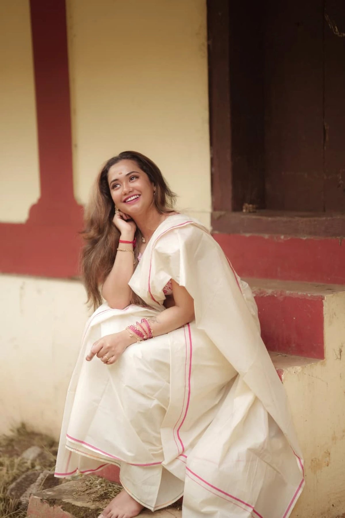 Naila Pink Puliyilakkara Settumundu with matching blouse material, seated look